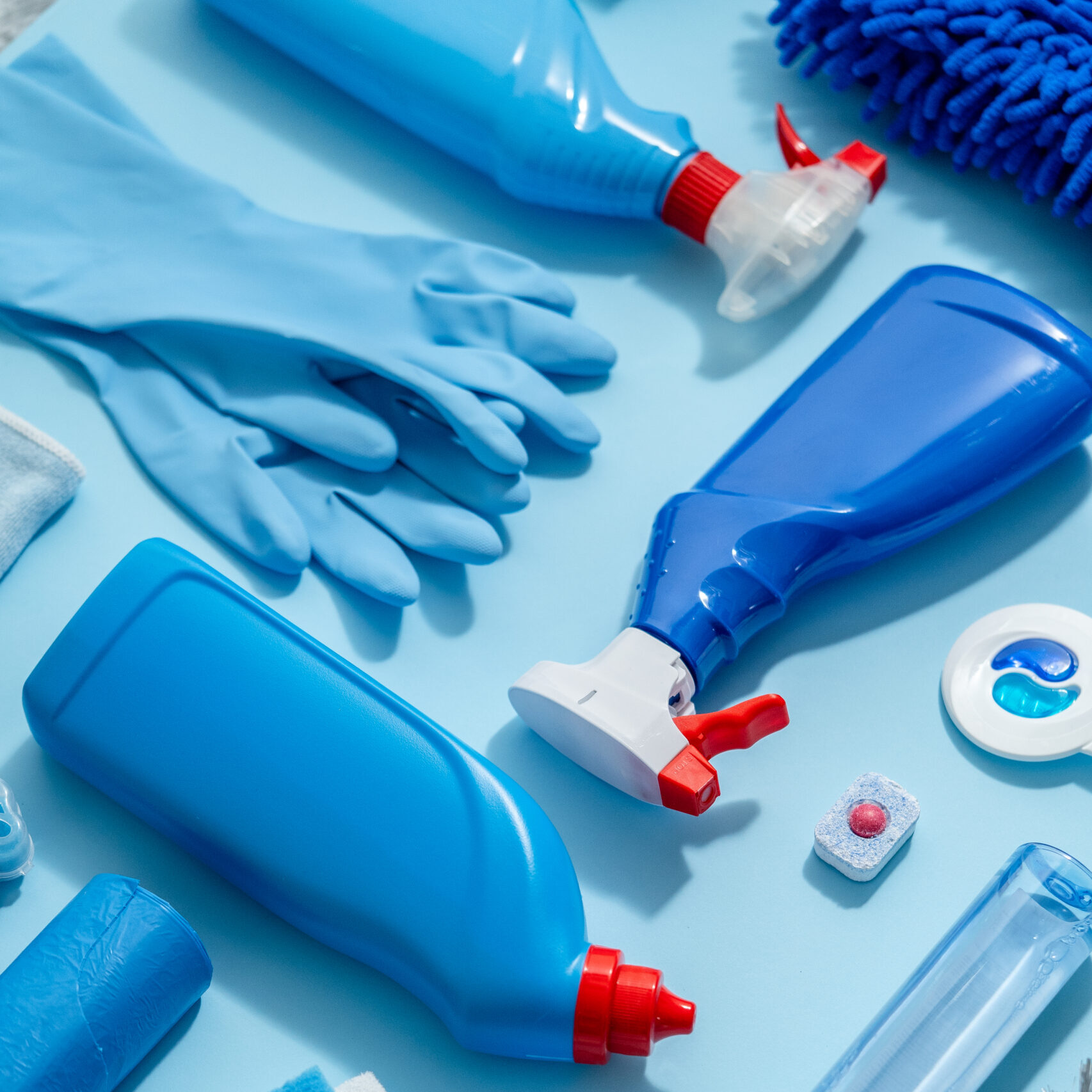 Colorful cleaning products on plain blue background. Housecleaning concept. Top view, flat lay